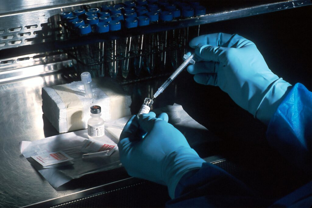A scientist looking at a sample through a microscope