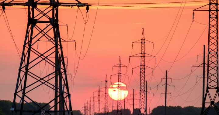 Electricity pylons against a setting sun